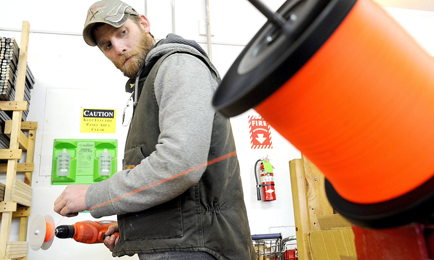 Tim Jackson, owner of Jack Traps drills a hole in the ice while